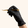 Lash Technician Holding Eyelash Extension tools while wearing Black Nitrile Gloves